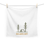 White towel with camping design and 'WE LOVE ADV' text hanging on a line.