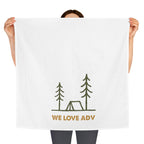 Person holding a white towel with 'WE LOVE ADV' and camping illustration on a white background