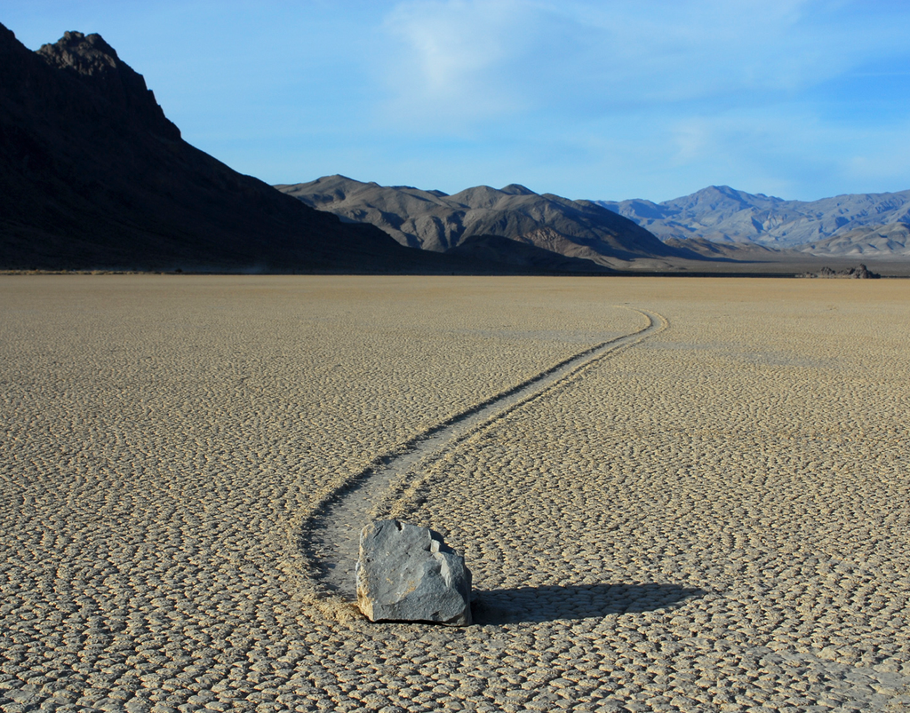 Desert landscape with a sliding rock and mountains in the background, unframed photograph